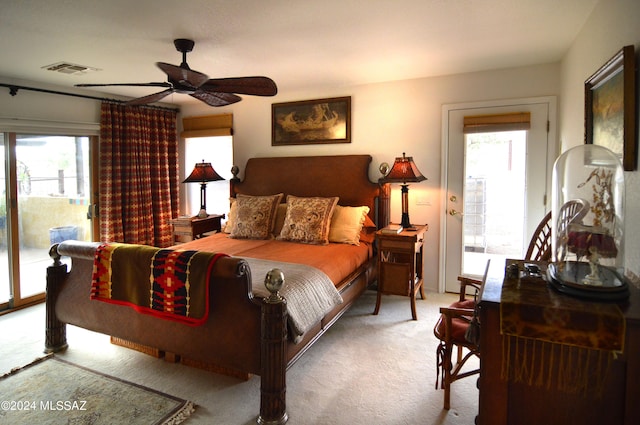 carpeted bedroom featuring multiple windows, access to exterior, and ceiling fan