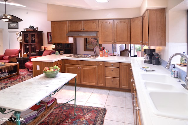 kitchen featuring sink, stainless steel gas stovetop, kitchen peninsula, and lofted ceiling