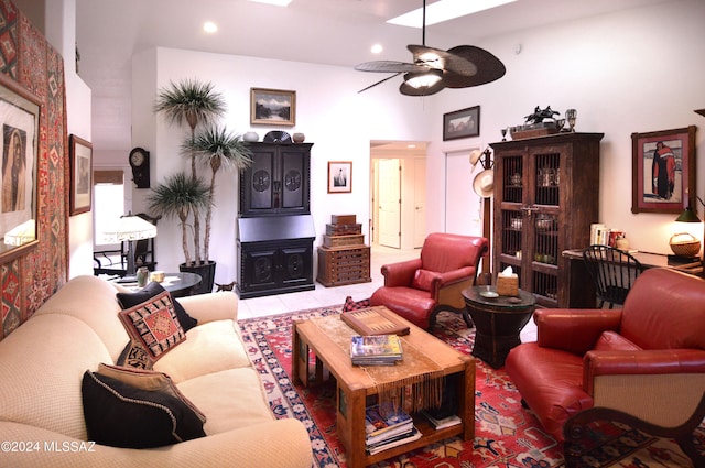 tiled living room with ceiling fan and a towering ceiling