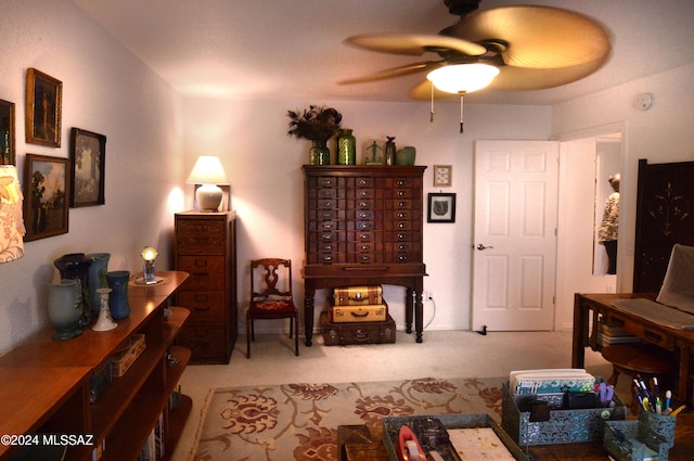 living area with light carpet and ceiling fan