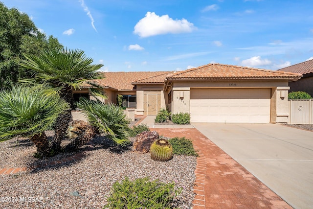 63156 E Flower Ridge Dr, Saddlebrooke, AZ 85739 - view of front facade with stucco siding, a garage, driveway, and a tiled roof