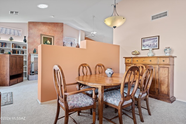 carpeted dining space featuring vaulted ceiling and ceiling fan