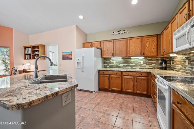 63156 E Flower Ridge Dr, Saddlebrooke, AZ 85739 - kitchen with white appliances, a sink, brown cabinets, decorative backsplash, and a center island with sink