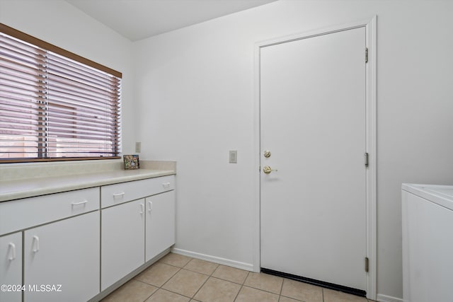 laundry area with washer / clothes dryer and light tile patterned floors