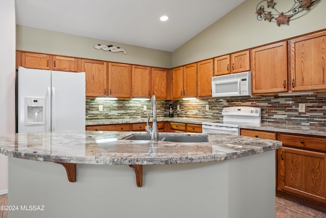 63156 E Flower Ridge Dr, Saddlebrooke, AZ 85739 - kitchen featuring white appliances, a sink, backsplash, brown cabinetry, and a kitchen island with sink