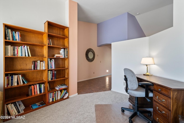 carpeted office with lofted ceiling