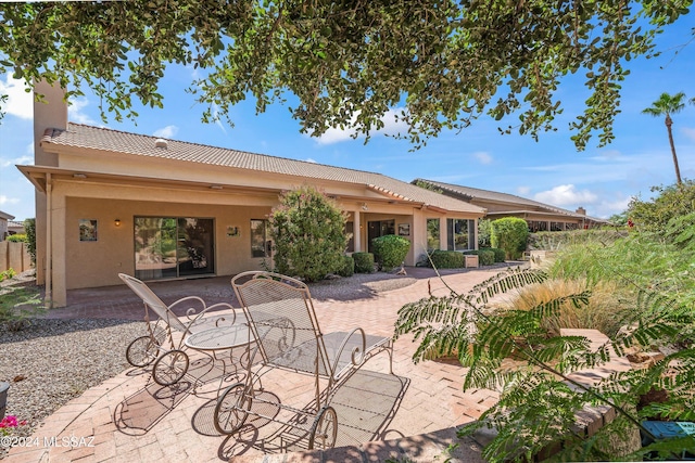 63156 E Flower Ridge Dr, Saddlebrooke, AZ 85739 - back of property featuring a patio, stucco siding, a tile roof, and a chimney
