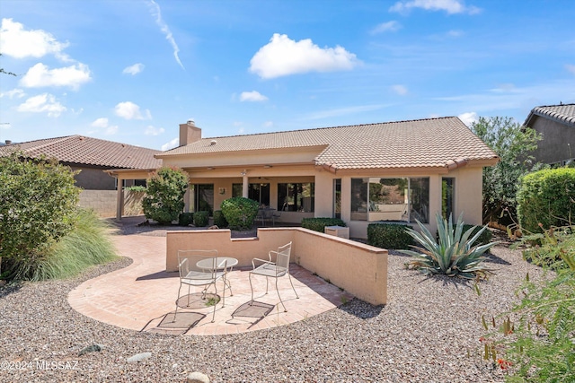 63156 E Flower Ridge Dr, Saddlebrooke, AZ 85739 - rear view of property featuring a tile roof, a patio, stucco siding, and a chimney