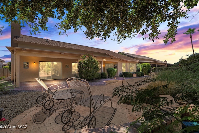 63156 E Flower Ridge Dr, Saddlebrooke, AZ 85739 - rear view of house with a patio area, a tiled roof, stucco siding, and a chimney