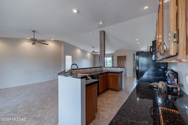 kitchen with sink, vaulted ceiling, kitchen peninsula, light tile patterned floors, and ceiling fan