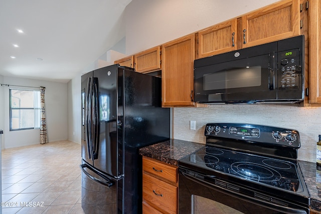 kitchen featuring black appliances, lofted ceiling, light tile patterned flooring, and decorative backsplash