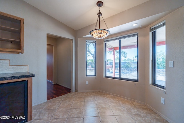 kitchen featuring lofted ceiling, light tile patterned floors, and decorative light fixtures