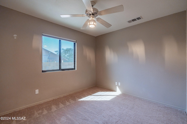 carpeted spare room featuring ceiling fan