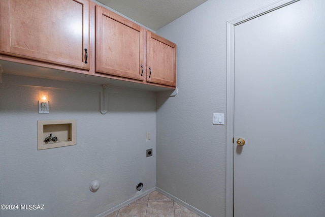 washroom featuring cabinets, washer hookup, electric dryer hookup, hookup for a gas dryer, and light tile patterned floors