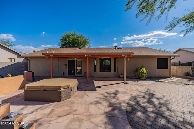 back of house featuring a patio area and a hot tub