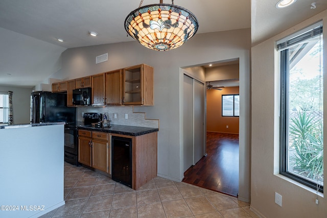 kitchen with hanging light fixtures, black appliances, lofted ceiling, and a wealth of natural light