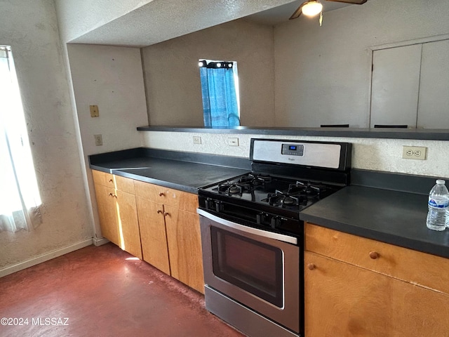 kitchen with ceiling fan, gas stove, and a textured ceiling