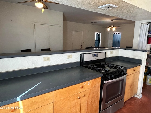 kitchen with a textured ceiling and stainless steel range with gas stovetop