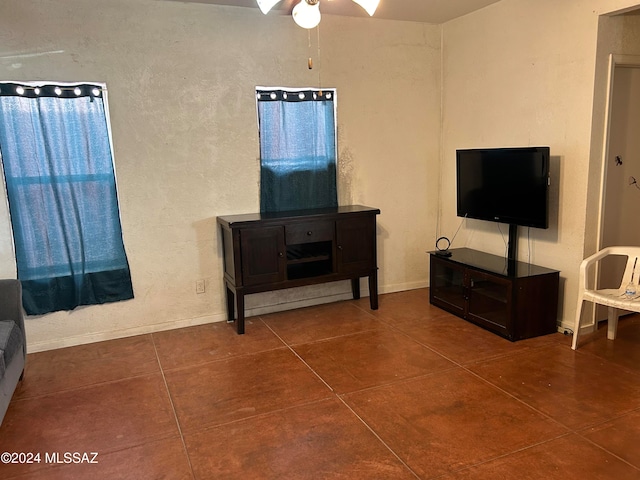 living room featuring dark tile patterned flooring and ceiling fan