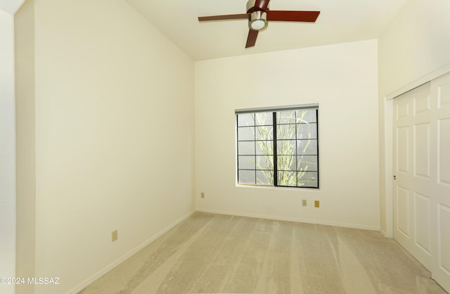 unfurnished bedroom featuring ceiling fan, light colored carpet, and a closet