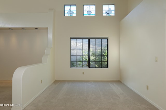 empty room with a wealth of natural light and light colored carpet