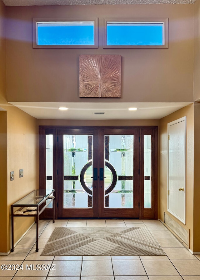 entrance foyer with light tile patterned flooring and french doors