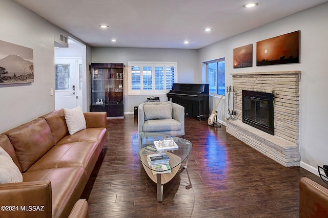 living room with a brick fireplace and dark hardwood / wood-style floors