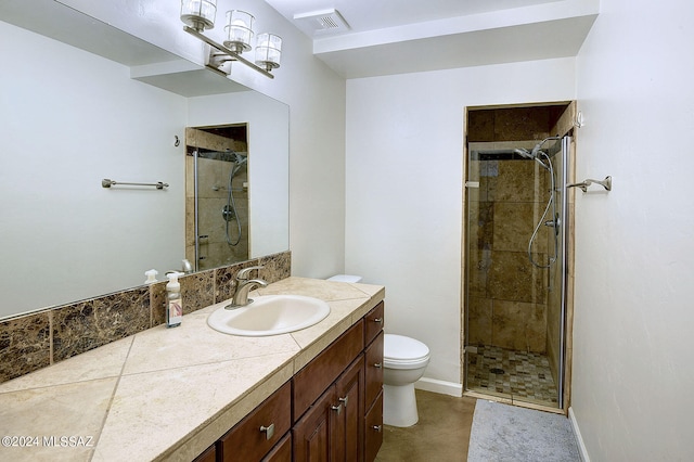 bathroom with a shower with door, vanity, toilet, and tile patterned floors