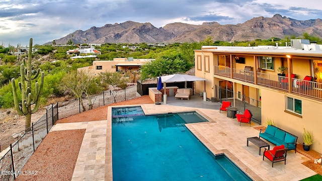 view of pool featuring a mountain view, a patio area, and an outdoor living space