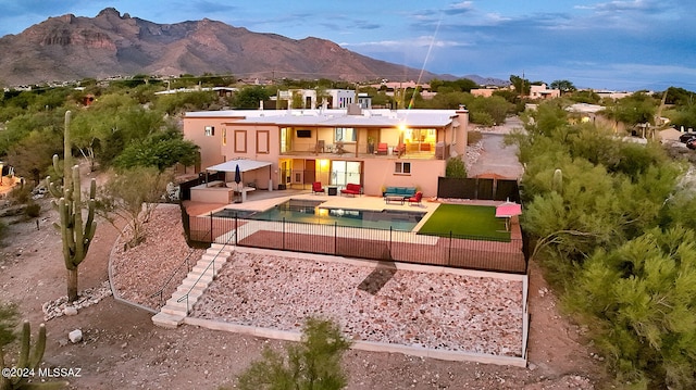 back of property featuring a patio, a mountain view, and a balcony