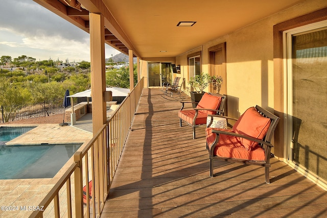 wooden deck with a patio area and a fenced in pool