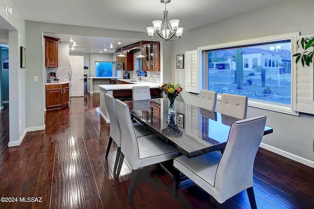 dining room featuring sink, dark hardwood / wood-style floors, and an inviting chandelier