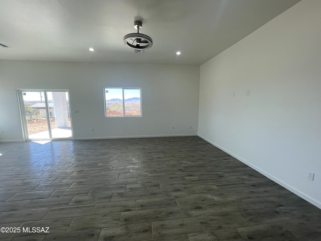 empty room with plenty of natural light and dark hardwood / wood-style flooring
