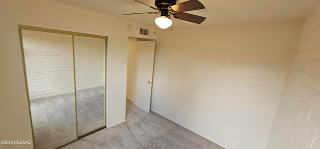 unfurnished bedroom with light colored carpet, a closet, and ceiling fan