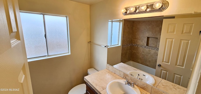 bathroom with toilet, vanity, and a wealth of natural light