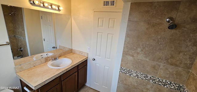 bathroom with vanity and a tile shower