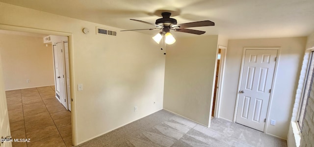 spare room featuring ceiling fan and light colored carpet