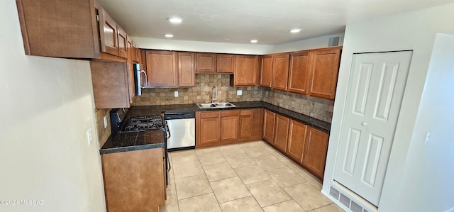 kitchen with sink, appliances with stainless steel finishes, decorative backsplash, and light tile patterned floors