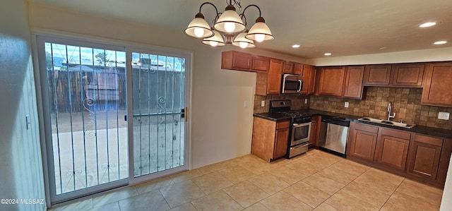 kitchen featuring stainless steel appliances, sink, decorative light fixtures, light tile patterned floors, and a chandelier