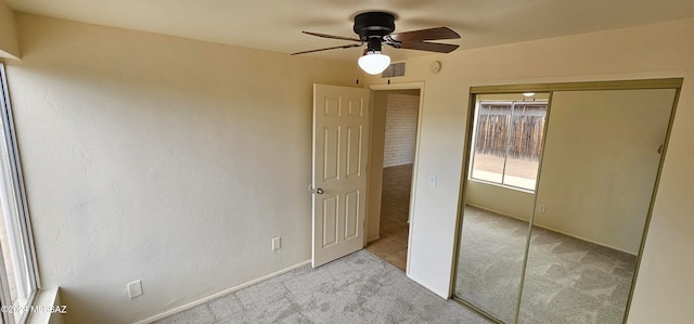 unfurnished bedroom featuring light carpet, a closet, and ceiling fan