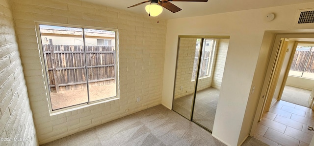 unfurnished bedroom with a closet, multiple windows, and light colored carpet