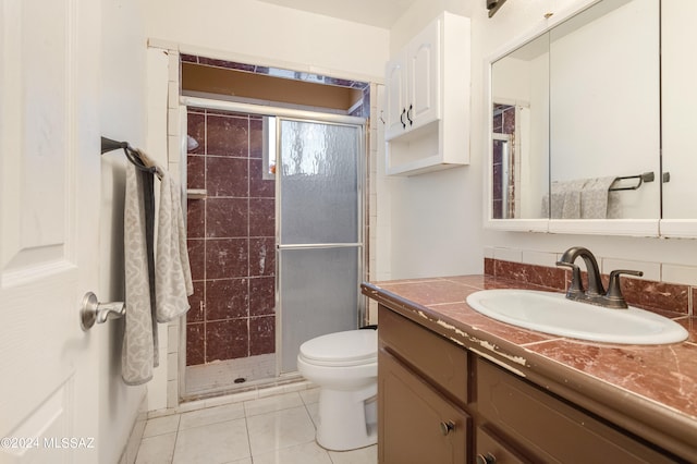 bathroom with vanity, toilet, tile patterned floors, and an enclosed shower