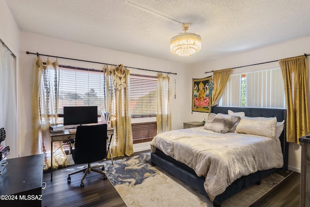 bedroom featuring a textured ceiling and dark hardwood / wood-style floors