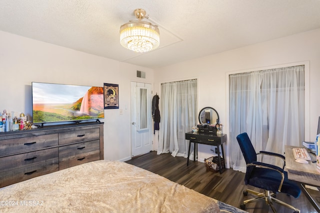 bedroom featuring a textured ceiling and dark hardwood / wood-style flooring