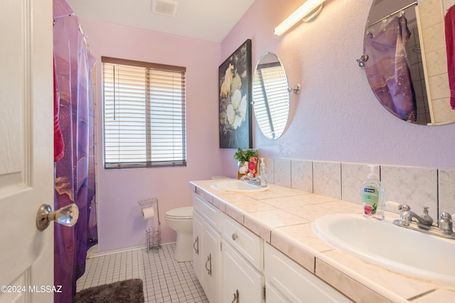 bathroom with tile patterned flooring, vanity, and toilet