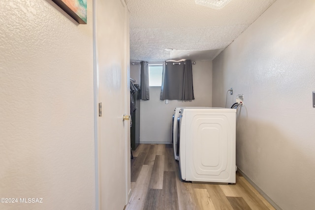 laundry room featuring hookup for a washing machine, a textured ceiling, and light wood-type flooring