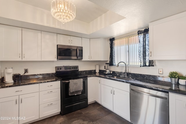 kitchen with white cabinets, appliances with stainless steel finishes, hanging light fixtures, and sink