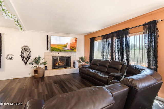 living room with a tiled fireplace and hardwood / wood-style flooring