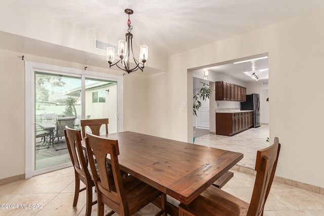 tiled dining room featuring an inviting chandelier