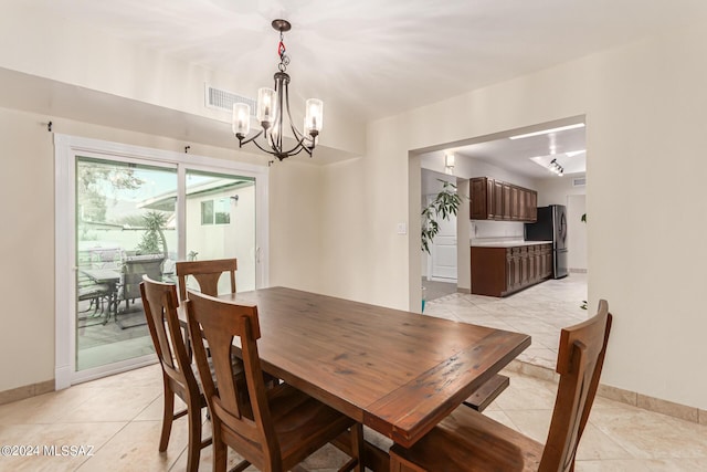 5731 E 2nd St, Tucson, AZ 85711 - dining room with baseboards, visible vents, a chandelier, and light tile patterned flooring